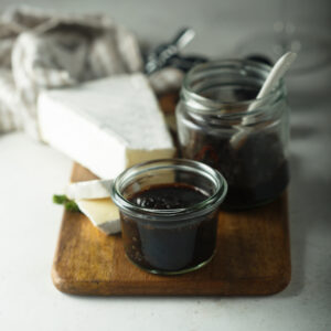 Composta di cipolle servita con formaggi su tagliere rustico.