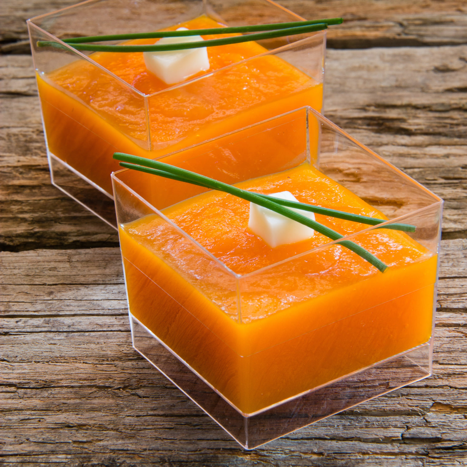 Crema di zucca servita in coppette gourmet con erba cipollina