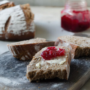 Fetta di pane artigianale con burro e composta di ciliegie senza zuccheri aggiunti.