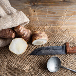 Topinambur fresco tagliato su juta con coltello da cucina