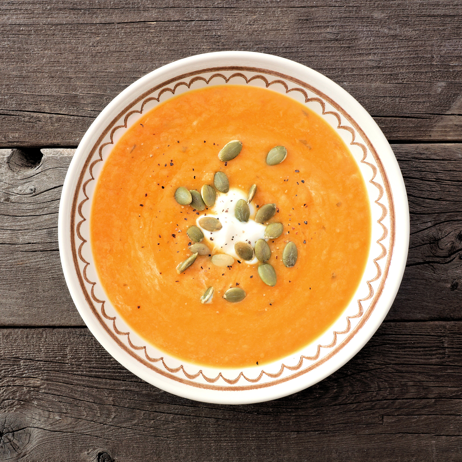 Vellutata di zucca cremosa con gocce decorative di panna